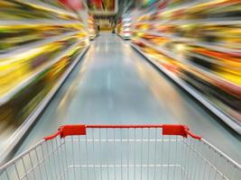 vista del carrito de compras en el desenfoque de movimiento del pasillo del supermercado foto