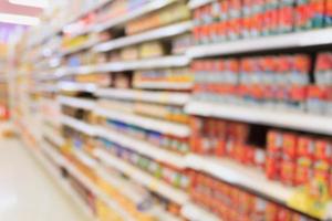 Canned food products in supermarket blurred background photo