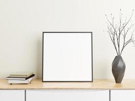 Minimalist square black poster or photo frame mockup on wood table with books and vase in a room. 3D Rendering.