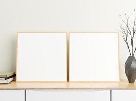 Minimalist square wood poster or photo frame mockup on wood table with books and vase in a room. 3D Rendering.