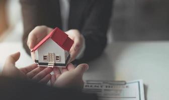 agente inmobiliario para comprar casa y terreno está entregando casa al cliente después de aceptar hacer un acuerdo de compra de casa. foto