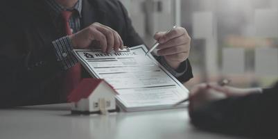 Real Estate Agent broker or House developer showing contract for buying house agreement to consultant employee. photo