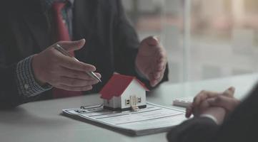 Real estate agent or sales manager has proposed terms and conditions to customers who sign house purchase agreements with insurance, Agreement to sign the purchase contract concept. photo