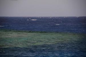 hermoso arrecife con agua de mar azul foto