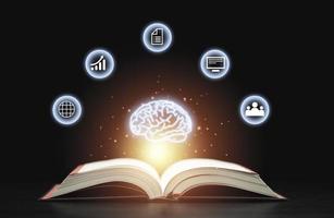 Glowing virtual brain floats above an open book with leaning icons on dark background which is a symbol of study  a knowledge will help solve problem and solution concept. photo