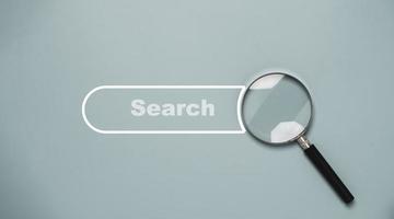 Magnifier glass with search bar icon for search engine optimisation or SEO concept.