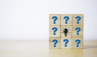 Drawing lightbulb print screen on wooden cube block among question mark for question and answer concept. photo