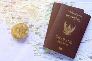 Gold bitcoins and Thailand passport are placed on the world map. photo