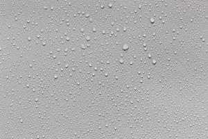 gotas de agua sobre fondo gris cubiertas de gotas de agua, burbujas en el agua. foto