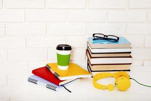 Workspace and education accessories on the table. Cup of coffee, books, glasses, notebooks, headphones. Stem education photo