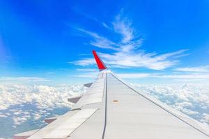 ala de avión en el cielo con hermoso cielo azul y nubes, vista aérea desde la ventana del avión. foto