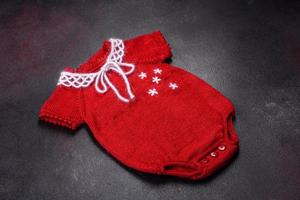 Clothing for a newborn baby knitted from red threads photo