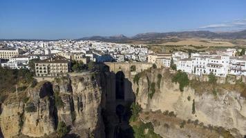 Aerial drone view of The Puente Nuevo, New Bridge in Ronda. White villages in the province of Malaga, Andalusia, Spain. Beautiful village on the cliff of the mountain. Touristic destination. Holidays. photo