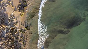 Amazing scenic drone aerial view of the beach and ocean with calm waves during a sunset with vibrant colors. Algarve, Portugal. Clear waters. Holidays and Vacations. Background. Beach with rocks. photo