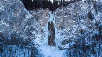 vista aérea de drones de cascada congelada con un poco de agua corriendo. hermoso y mágico paisaje de vacaciones de invierno para los amantes de la naturaleza. paisaje fuera del mundo de narnia. turismo inimaginable de cuento de hadas. foto