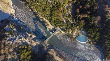 Aerial drone view of people swimming and bathing in hot springs thermal baths on a winter sunny day. Beautiful natural wonders. Connecting with nature. Freedom and searching for a pure state of mind.