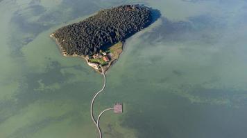 Aerial drone view of a beautiful semi island in the middle of the lake. Beautiful colors in water and amazing landscape. Travel the world and find the wonders. Relax and meditate. Holidays are coming. photo