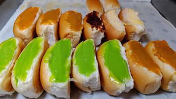 Bread stuffed with steamed green and orange custard sales in the market in Thailand photo