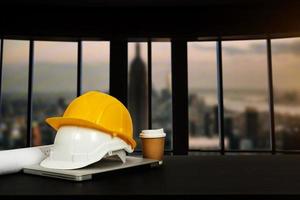 Front view of laptop computer and office construction on table in office blurred background.Architect concept. photo