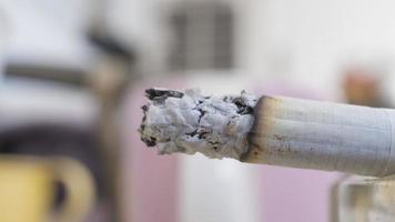 Macro shot of a burning cigarette. Selective focus with DOF. Unhealthy habit concept. photo