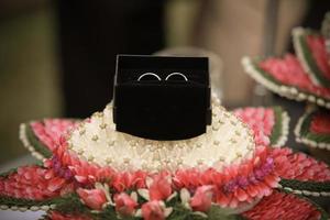 frontal de un anillo de compromiso preparándose en una bandeja de flores en el día de la boda. detalle de boda en tailandia tradicional. foto