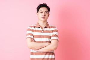 joven asiático posando sobre fondo rosa foto