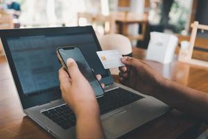 banca de crédito comercial y servicio de compras en línea, primer plano de manos de mujeres de negocios usando tarjeta de crédito para pagar compras en línea en la web de comercio electrónico en una cafetería. pago de compras con tarjeta de crédito foto