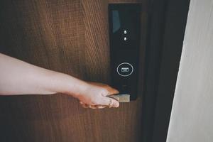 Woman Hand is Holding Door Handle While Opening a Door for Access Apartment Building. Electric Door With Keypad Code for Security System in Apartments Room. Electronic Door for Entrance-Exit Building. photo