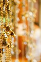 The golden bell hanging on a chain has a blurred background. photo