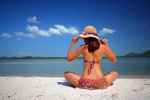 acción libre y relajación de una chica bronceada en bikini en la playa de arena blanca en krabi, tailandia. imagen conceptual para vacaciones de verano en un país tropical. foto