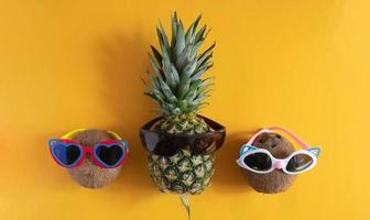 A smart pineapple in sun glasses and bright beads. Minimal concept, summer tropical pineapple.Summer, vacation, party photo