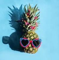 hipster de piña en gafas de sol. concepto mínimo, piña tropical de verano.verano, vacaciones, fiesta foto