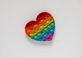 color pop it juguete antiestrés para niños. Arco iris en forma de corazón aislado sobre fondo blanco. foto