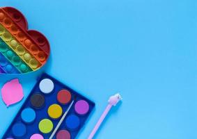 Back to school concept. School and office supplies on the office table and antistress toy. Flat lay photo