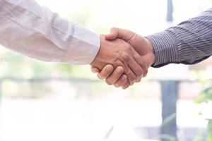 Dos hombre de negocios confiado dándose la mano durante una reunión en la oficina, el éxito, el trato, el saludo y el concepto de socio