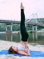young fit woman in sportswear in different yoga asanas outdoor on the beach by the river. Yoga and sport concept photo