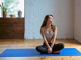 mujer joven en forma en ropa deportiva en diferentes asanas de yoga en interiores. concepto de yoga y deporte foto