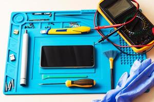 Flat lay image of dismantling the broken smart phone for preparing to repair or replace some components, Top view photo