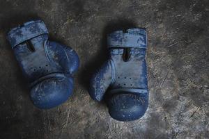 Old blue Boxing gloves on a concrete background. photo