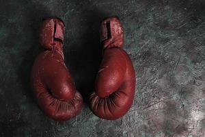Old red Boxing gloves on a concrete background. photo