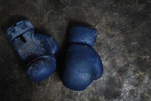 Old blue Boxing gloves on a concrete background. photo