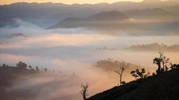 Mountains with thick fog and a morning sun rise in the countryside. photo