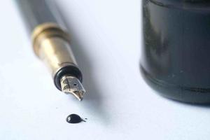 ink, empty paper and fountain pen on table photo