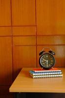 stack of notepad and clock on table with copy space photo