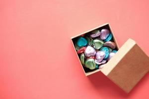 multi color heart shape candy in a box on red photo