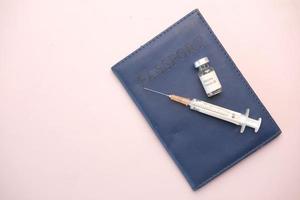 vista superior de la vacuna contra el coronavirus y la jeringa en el pasaporte foto