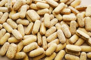 Close up of many vitamin pills on white background photo