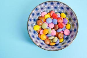 Caramelos dulces multicolores en un recipiente de cerca foto