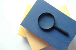 open book and magnifying glass on table. photo