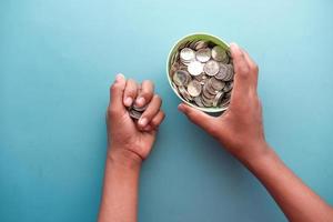 young man saving coins in a jar white sited photo